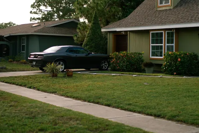Sidewalk and street in front of a house with a lawn